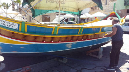 Marsaxlokk, Malta. A Luzzu vessel is getting an extra coat of paint before going back to the water. In this occasion, the boat will be used for taking tourists around the harbor and the peninsula. However, traditional sea vessels are also repainted before going back fishing or just for the pleasure of the locals to enjoy painting them and put them back into the water as part of their leisure time (Photo: Jordi Vegas Macias).